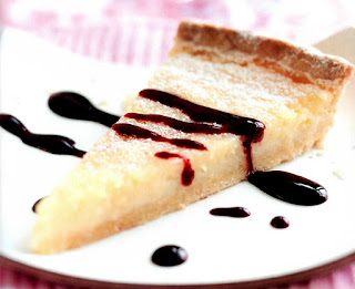 Tart au citron with cassis sauce: Classic French lemon tart served as a slice drizzled with cassis sauce