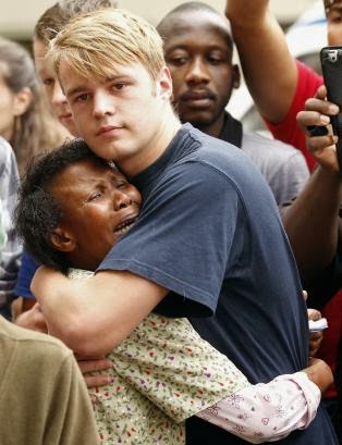 Una mujer negra y un hombre blanco lamentan el fallecimiento de Mandela