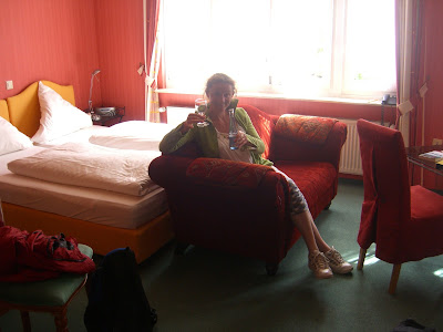 Hotelkamer die eruitziet als een bordeauxrood boudoir.
