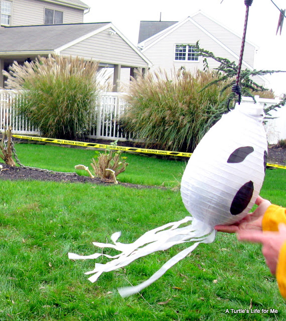 A paper lantern decorated like a ghost turned into a pinata