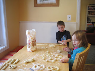 Children rolling dough into pretzel shapes