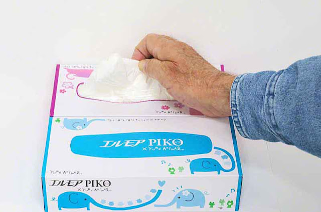 Hand pulling several tissues from new box