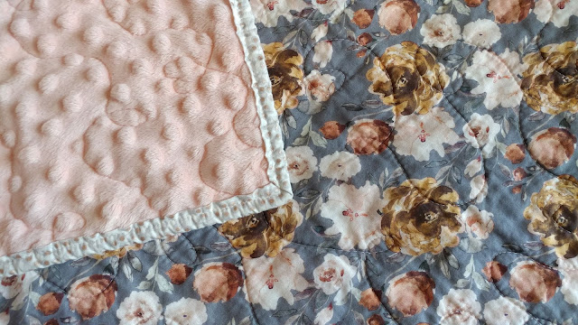 This trendy floral whole cloth quilt with soft minky back is the perfect baby quilt for a girl!
