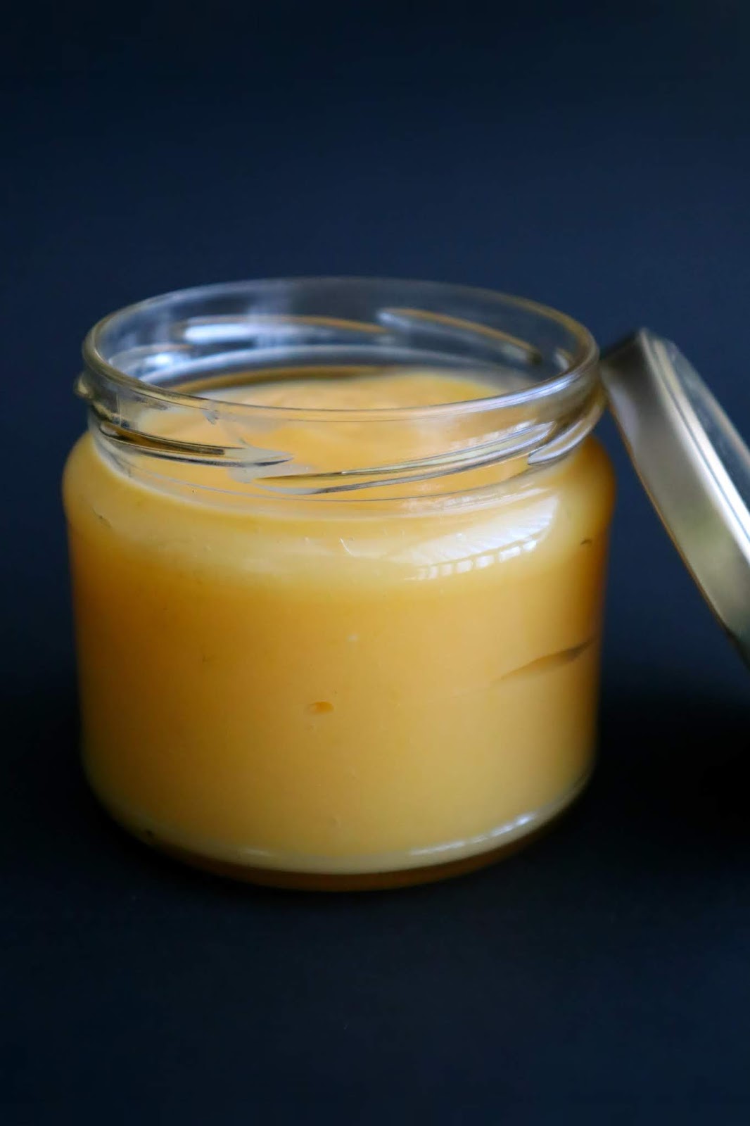 Creme de limão (Lemon curd) Frasco aberto contendo creme de limão, e tampa encostada ao frasco