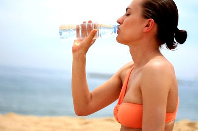 Woman in bikini drinking water