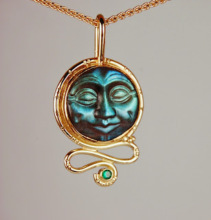 18k yellow gold pendant with carved moon face and emerald
