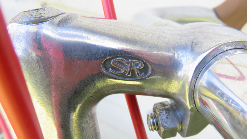 Bicycle Handlebar stem with red reflection of brake wire