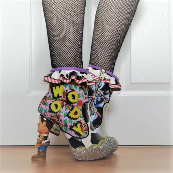 Irregular Choice You Are A Toy! ankle boots side angle of legs in black fishnets with cow print ankle boots and Woody Toy Story heel