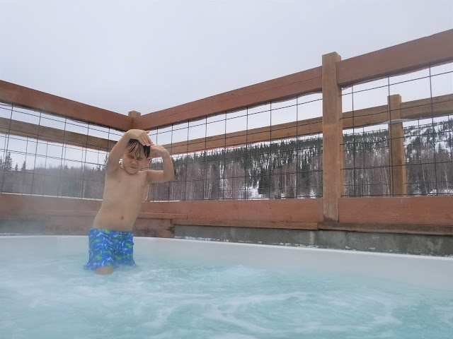 Boy having a great time in outdoor hot tube in Chena Hot Springs Resort