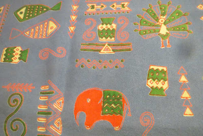 Tablecloth detail with red elephant and green peacock
