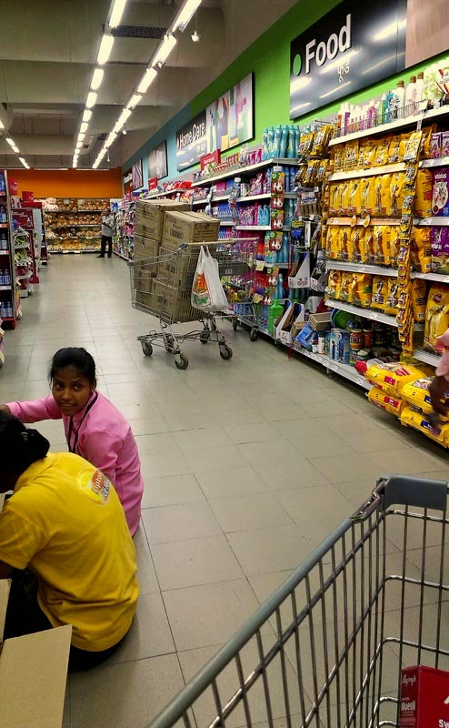 Supermarket employees arranging goods