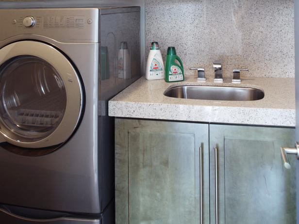 This view of the laundry room shows the large laundry sink, full size dryer and washer. DECORATION: LAUNDRY ROOMS