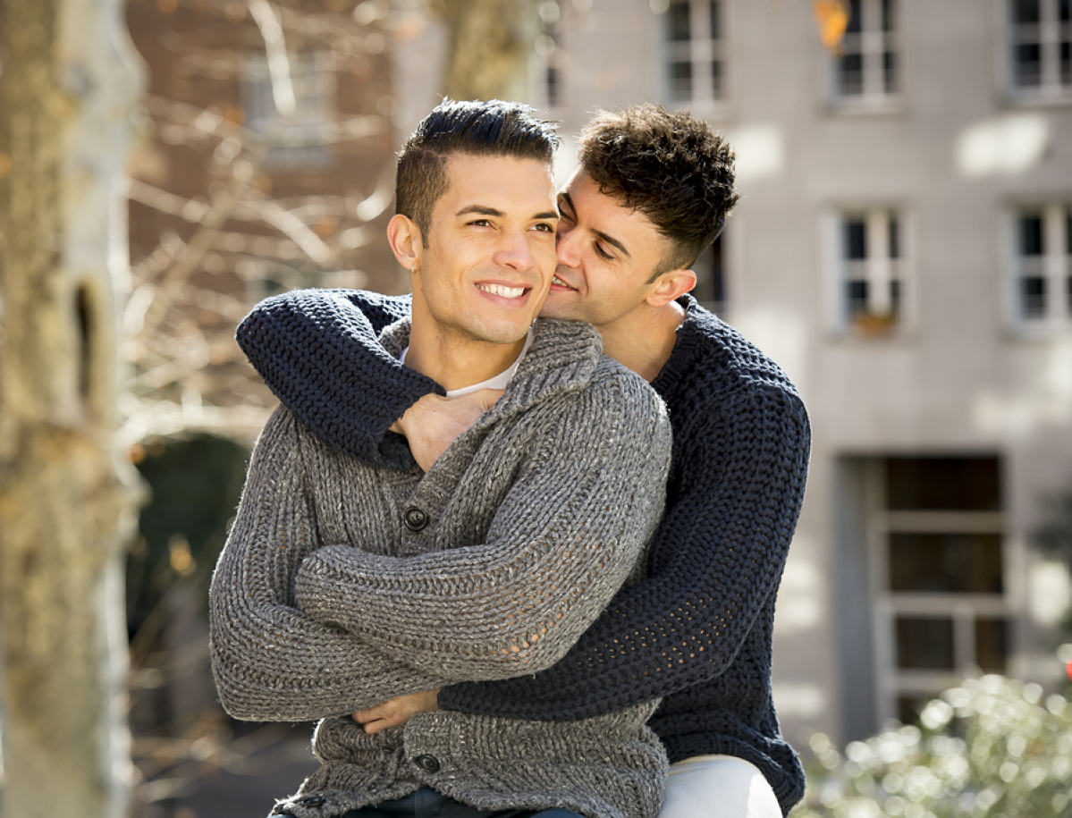 Gay couple kissing on beach