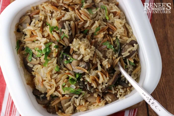 Overhead view of Easy Mushroom Rice Pilaf by Renee's Kitchen Adventures in white serving bowl with spoon