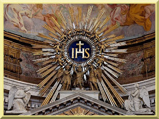 IHS monogram, with kneeling angels, atop the main altar, Church of the Gesù, Rome. Public Domain