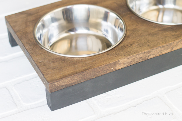 It's so easy to build this DIY raised pet feeder! Perfect idea for small dogs or cats. Get modern farmhouse style with black and wood tones.