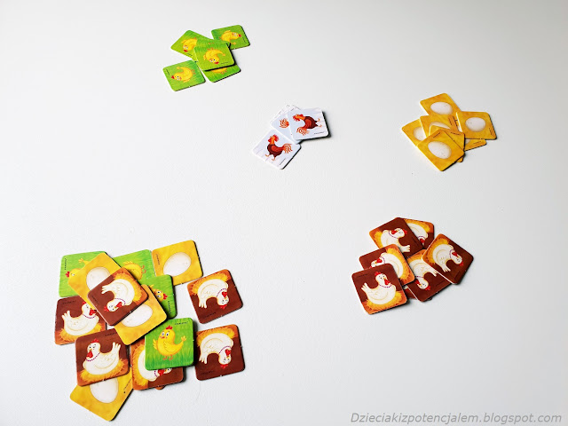 Gra Pepco pełny kurnik na zdjęciu elementy gry rozłożone na cztery stosy, jeden zmieszany i trzy posegregowane według rodzaju zwierzęcia na kafelku