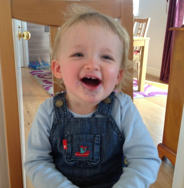 toddler sat on chair with blueberry stain around mouth