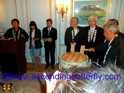 Far Left at the Podium: Mr. Kosuke Kuji, Senior Managing Director Nanbu-Bijin Co.,Ltd at drum Center: Ambassador Sumio Kusaka, Consul General of Japan in New York getting ready to break the ceremonial drum at the Ninohe City Reception