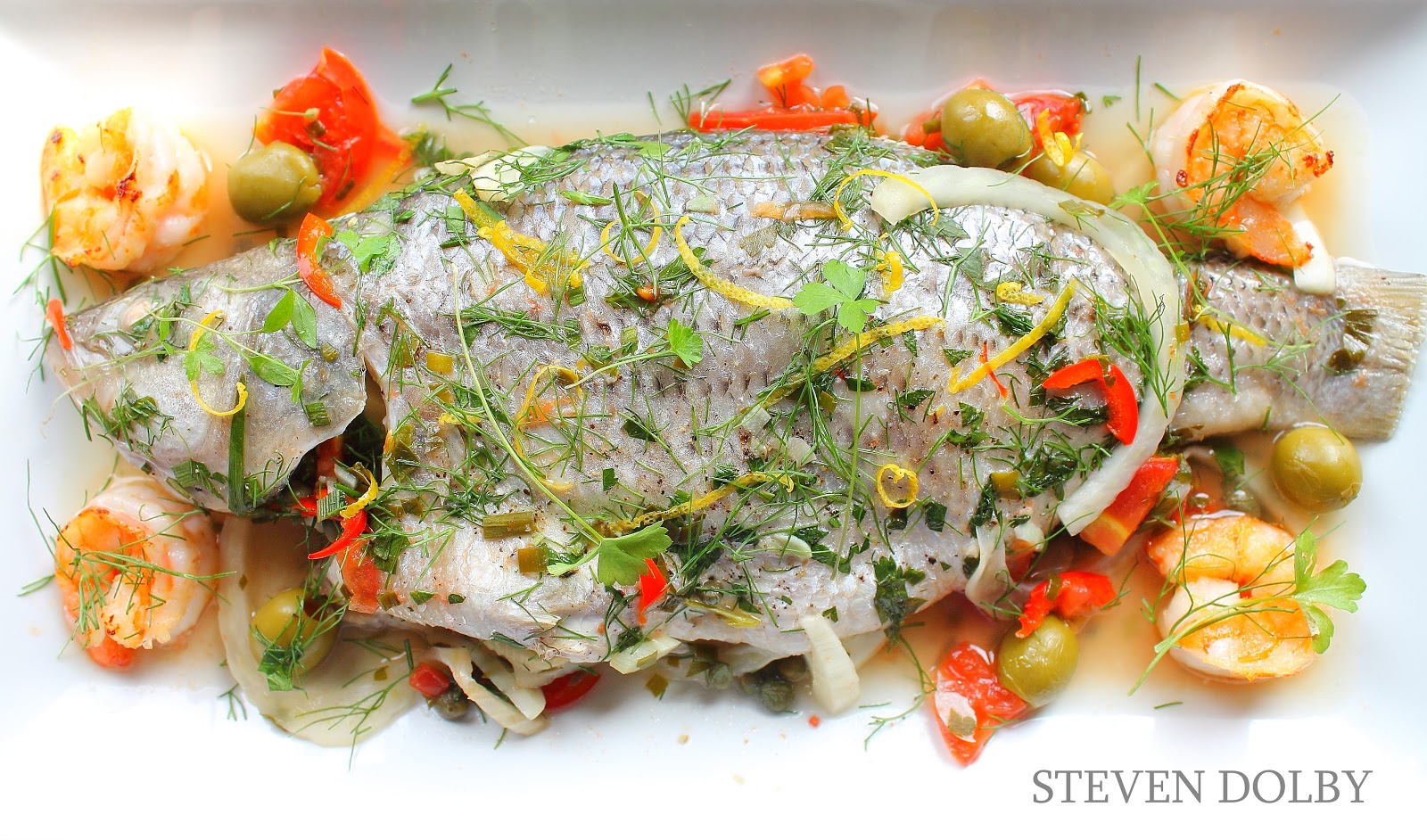 Striped bass stuffed with fennel, lemon, tomatoes, olives & capers Mediterranean style by Steven