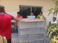 Un palé con botellas de agua y un grupo de personas alrededor Terremoto Ecuador, misioneros, Manta