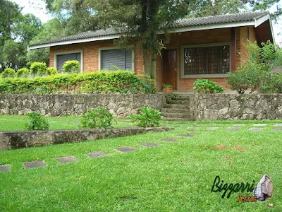 Execução do caminho do jardim com pedra folheta de granito tamanho 40x60 cm com os muros de pedra, a casa de tijolo a vista em sítio em Bragança Paulista-SP.