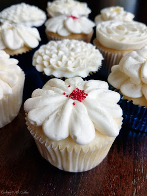 Fluffy white cupcakes are made perfect with a cake mix and a lot of add ins to make them special. They are the perfect texture, flavor and will quickly become your favorites as well! close up of frosted semi-homemade white cupcakes