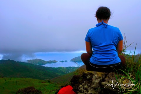 A girl meditating at the peak of mountain Cinco Picos overlooking the sea Silanguin Cove hover_share