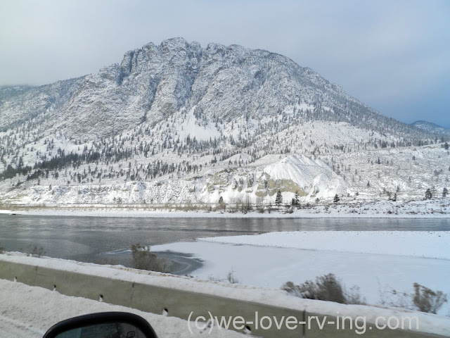 Snowy mountain is the backdrop from the highway across the river.