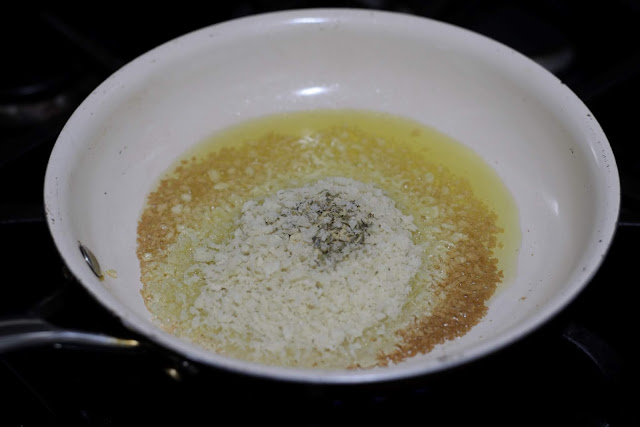 Panko bread crumbs and seasoning added to the oil in the pan. 