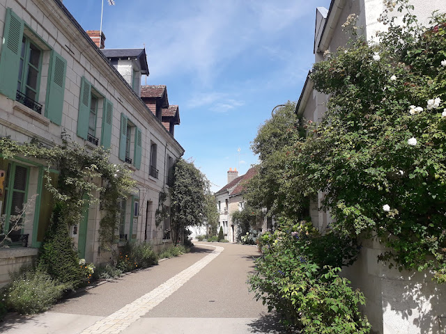 The main street of the village of Chedigny in August showing greenery