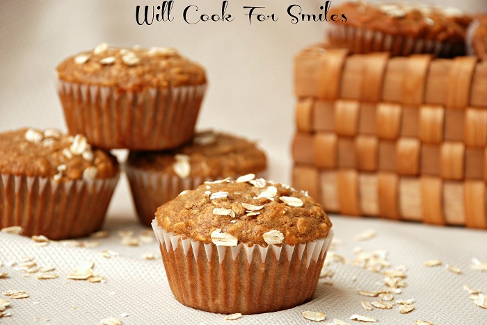oat muffin stacked up on a cream colored table cloth with oats around it