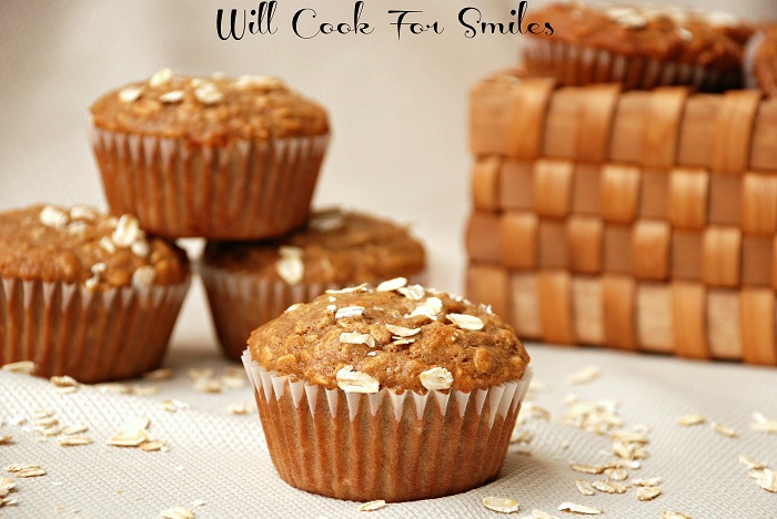 oat muffin stacked up on a cream colored table cloth with oats around it 