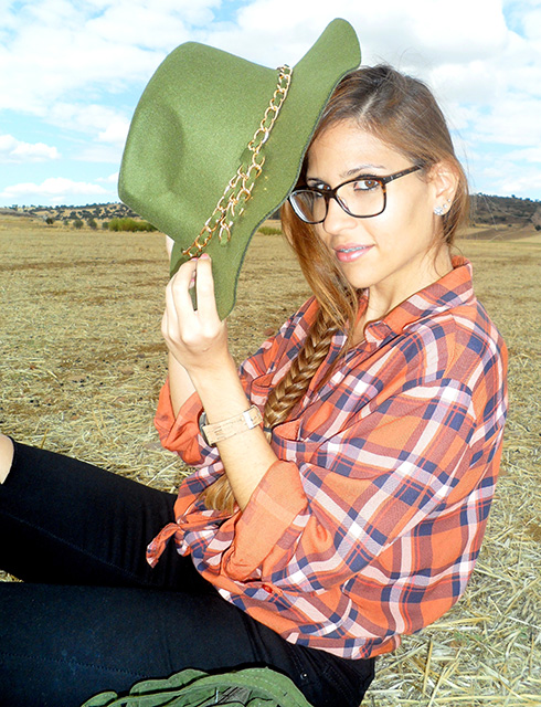 Camisa de cuadros con vaqueros rotos, botas boho, sombrero y bolso