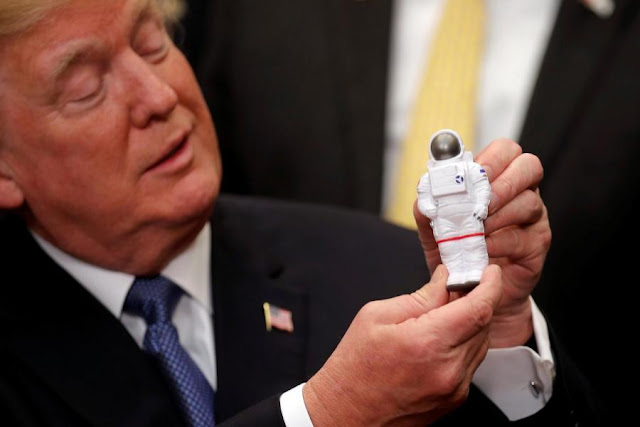 Presidente Donald Trump segura boneco de astronauta
