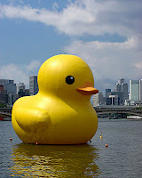 giant rubber ducky floating in a city harbor