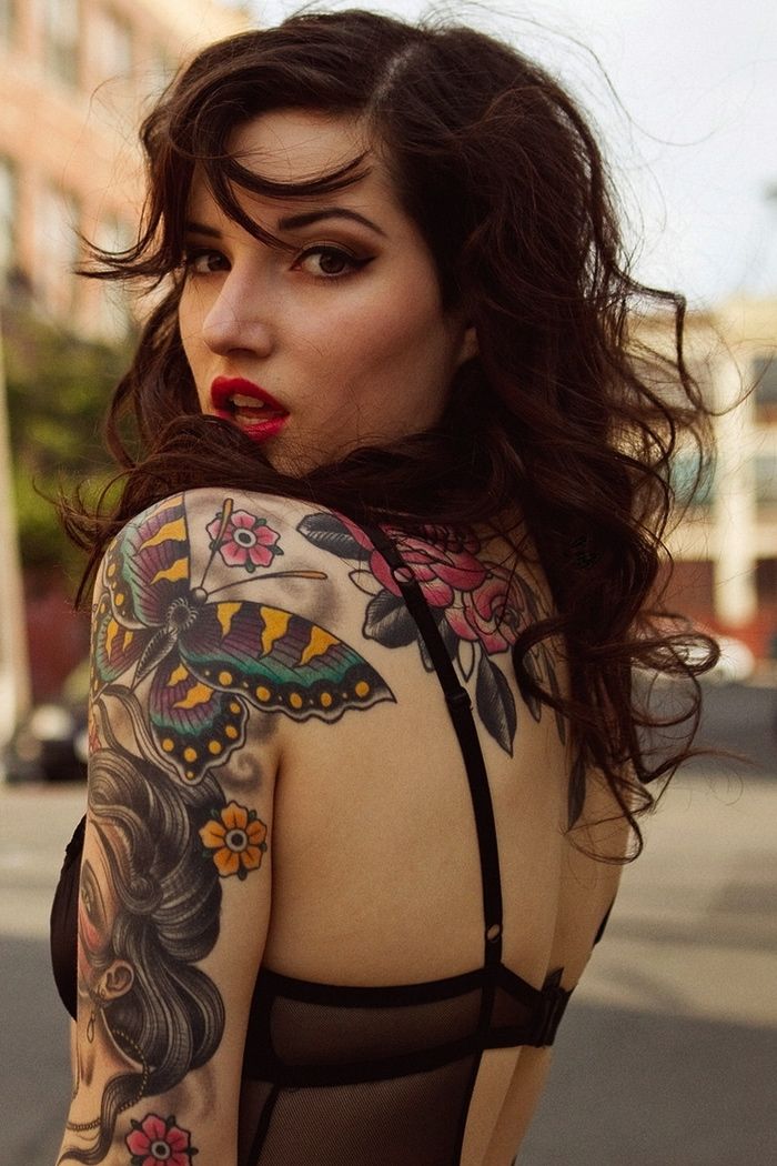 modeo con tatuajes femeninos que le cubren el cuerpo, esta posando muy seductoramente