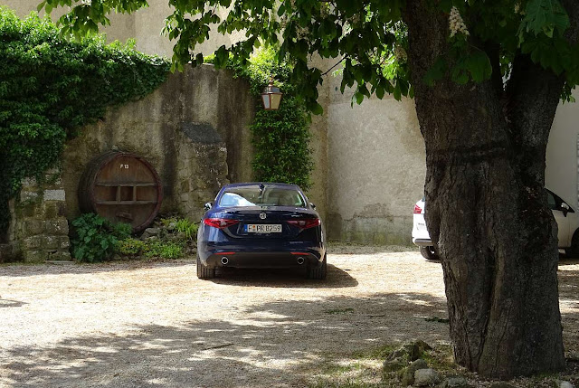 Alfa Romeo Giulia Super parks under a tree in front of the saleroom of Château Bas