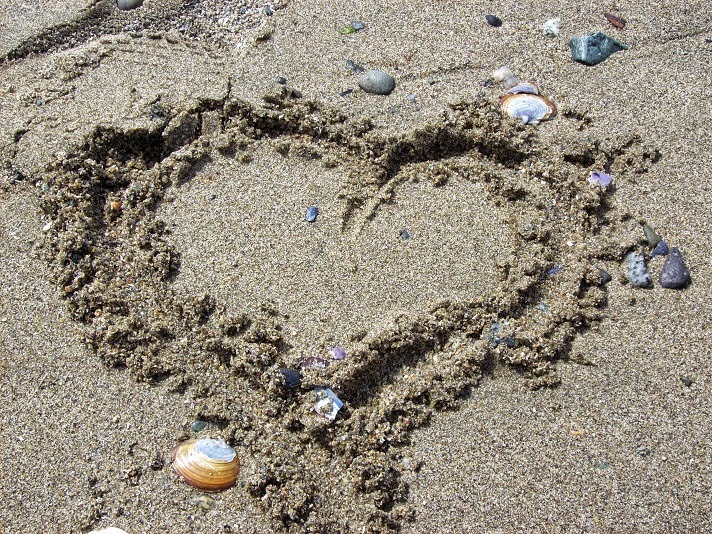 Heart drawn from sand on the beach