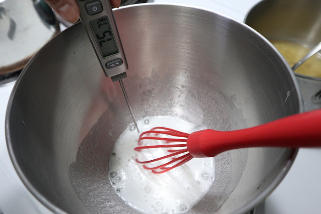 whipping egg whites while measuring the temperature for macaron buttercream making