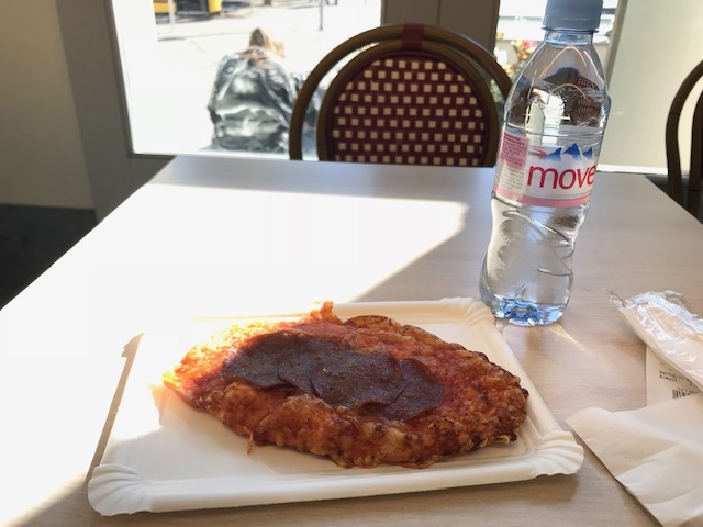 スイス　バートラガツの駅構内のお店でピザを食べる