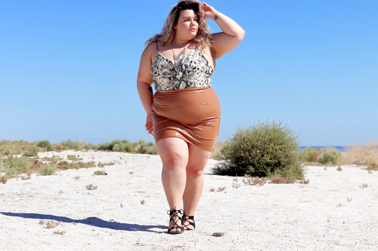 Chicago Plus Size Petite Fashion Blogger, YouTuber, and model Natalie Craig, of Natalie in the City, reviews Fashion Nova Curve's Slither My Way Bodysuit and Boot Camp Latex Skirt.