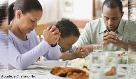 Familia orando antes de comer en restaurante 