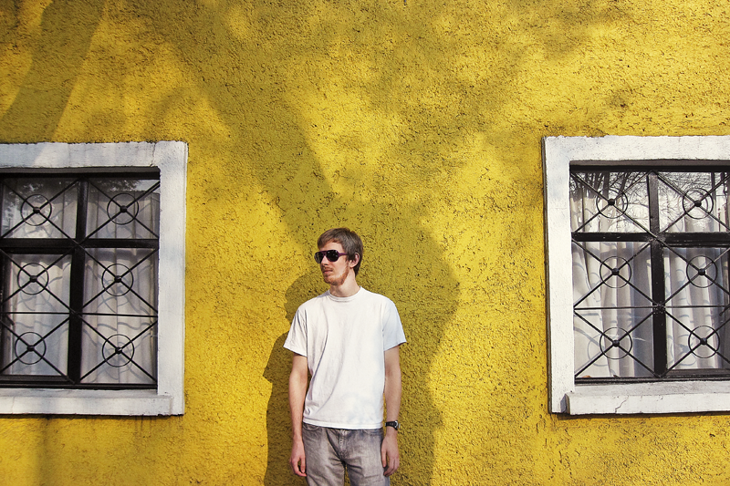 Standing against a bright yellow wall in Coyoacan in Mexico City