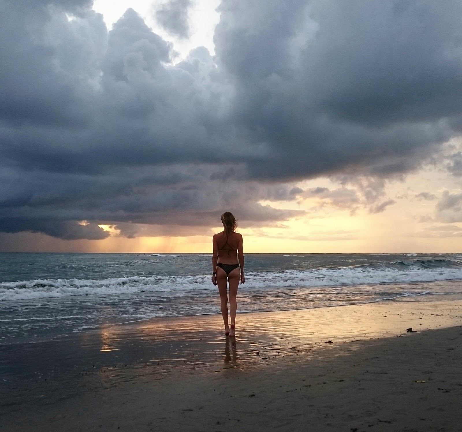Fashion and travel blogger, Alison Hutchinson, swimming at sunset in a Amuse bikini in Bali