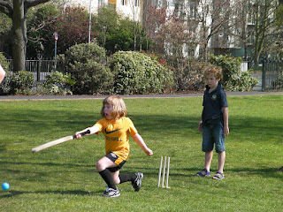 girl in football kit playing cricket