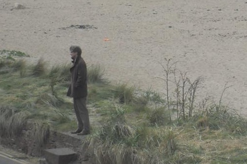 Colin Firth standing on a wall