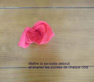 mettre la serviette debout et écarter les pointes de chaque côté