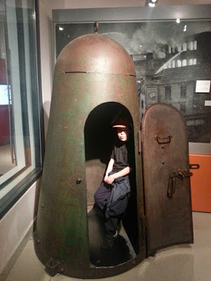 Boy sitting in a bomb shelter at M Shed
