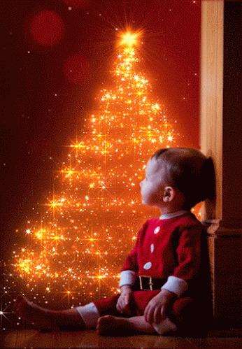  Niño junto al arbol de navidad con luces y destellos